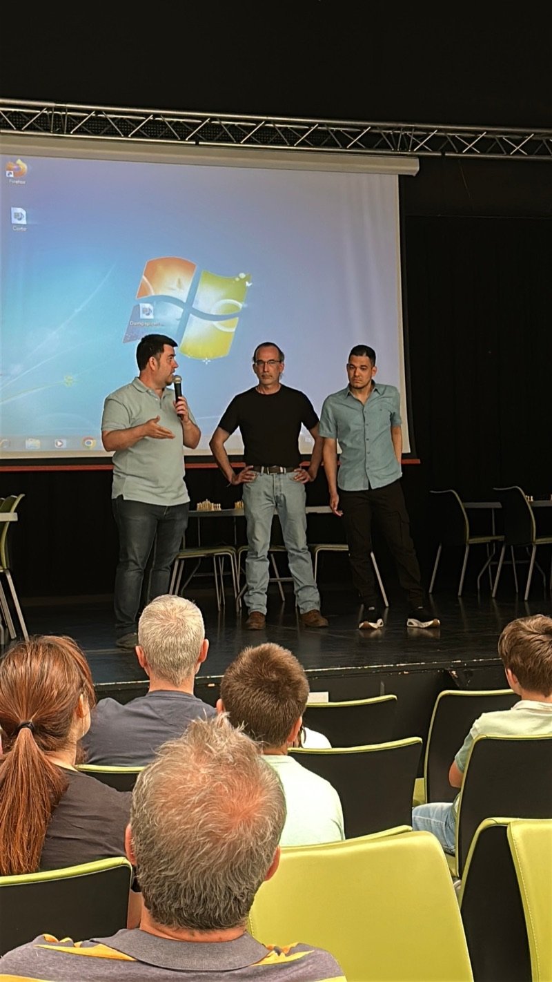 Presentación del evento en el escenario del salón de actos, con público sentado en primer término