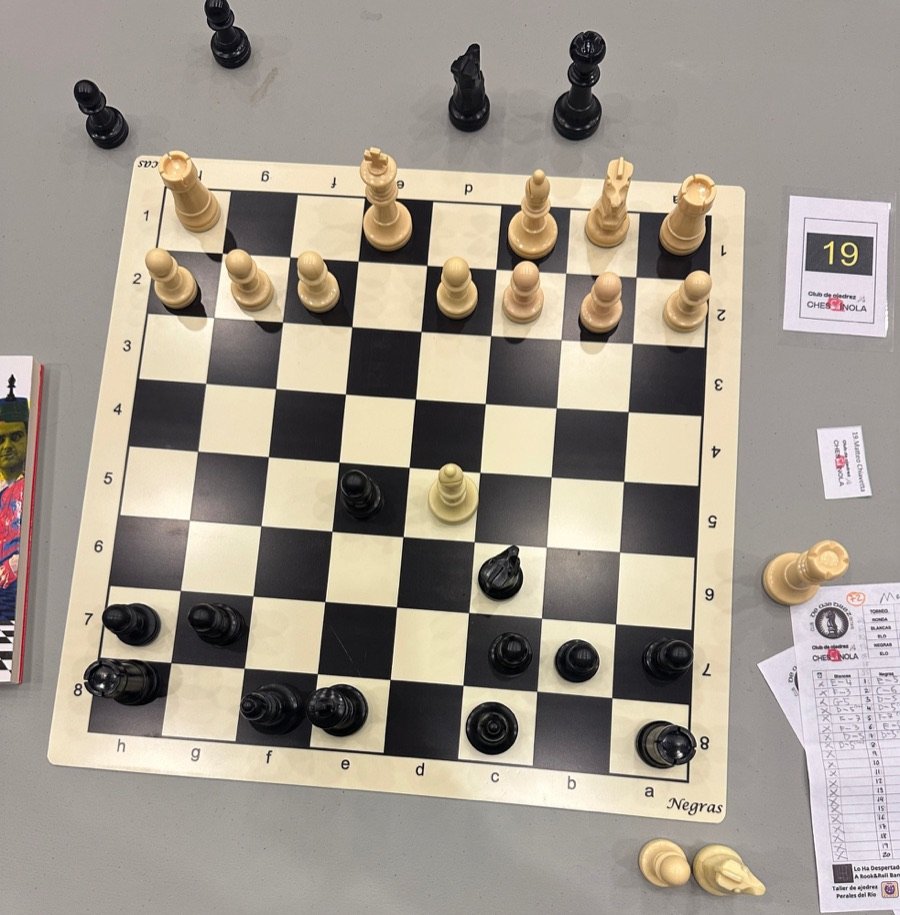 Tablero número 19 durante unas partidas simultáneas, con la planilla de jugadas al lado